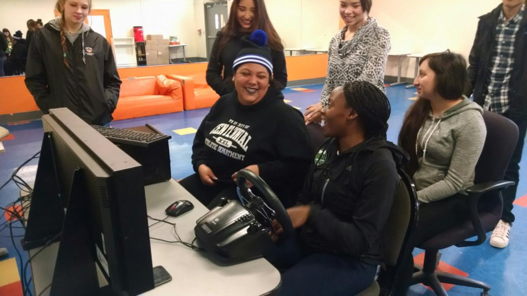 Teens practice driving on the simulator.