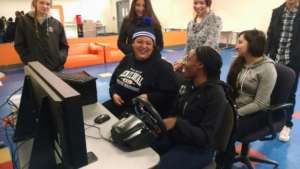 Teens practice driving on the simulator.