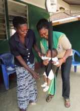 AMS Social Worker, Linda weighs a baby client