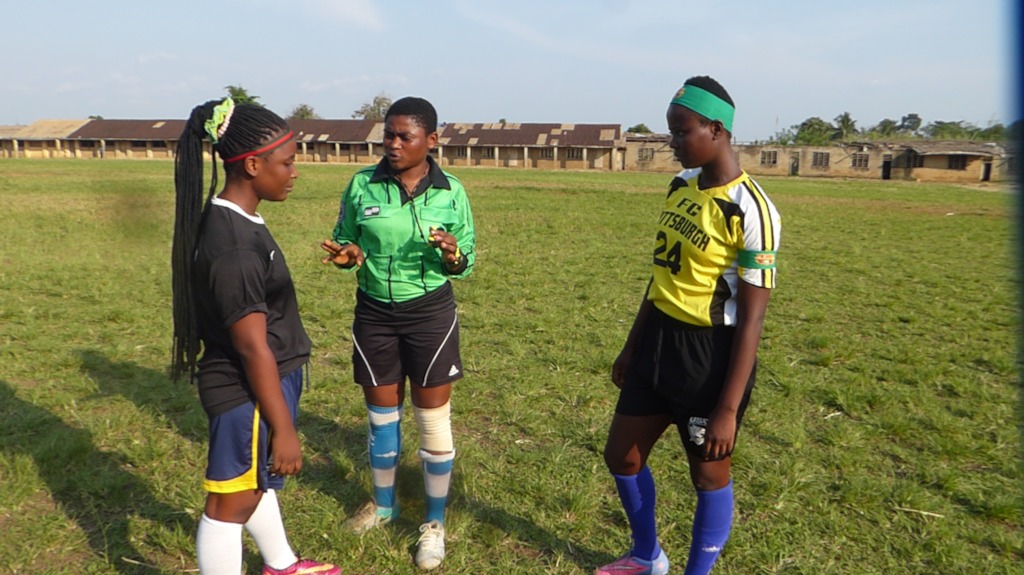 Players chat with a peer referee before kickoff.