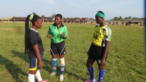 Players chat with a peer referee before kickoff.