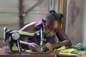 A member of the Adult Survivor Network sews masks.