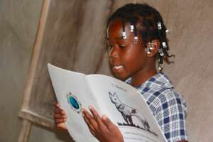 A student reads a book written by a fellow student