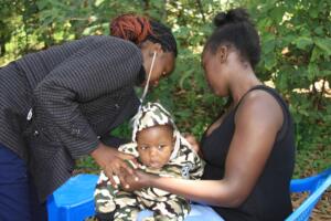 A community Health nurse treating a sick child.