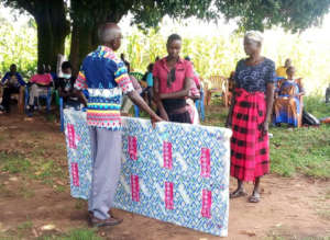 Gifty and her parent receiving award of a mattress