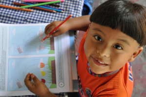 Jorgito working in his activity book at home