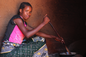 Margaret's daughter cooks maize from Forest Garden