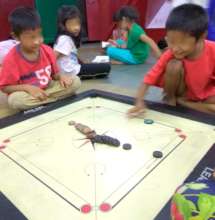 beneficiaries enjoying a game of carom