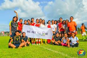 Girls team with 'We are all One' Sign