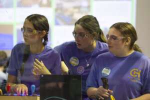 Drive team watches autonomous robot compete.