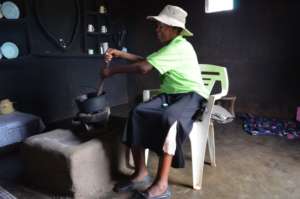 Esnath cooks at her new clay stove
