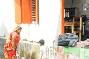 A mother and her son are collecting water