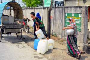 People carrying water through rickshaw van