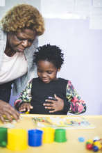 Teaching a child one of the Ndinogona activities