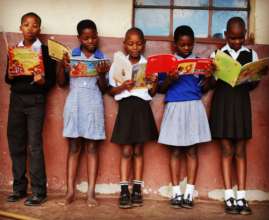 Beneficiaries reading books donated by Biblionef
