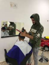 Aqueel cutting hair in Azraq Camp, Jordan