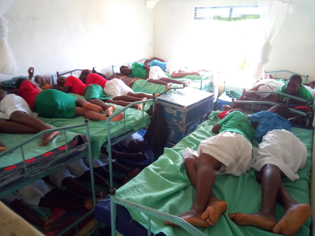 Girls demonstrate how they sleep 2 per bed.