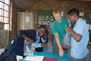 Micah with students measuring sand composition