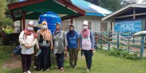 Teachers in front of new water tank for station