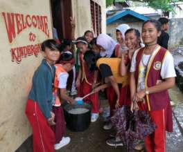 Girls at school feeding younger students
