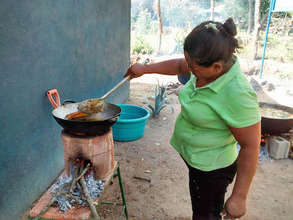 A mother cooking using an ecostove.