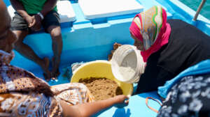 Women preparing the discs - mixing sand and cement