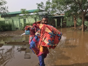 Shishpal carrying blankets across the floodwater