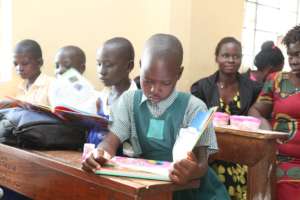 Children reading their newly received book prizes