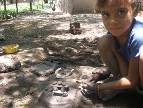 Little girl making a stove, like her mother.