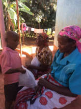 Daniel from Pre-Primary 2 handing out bags of seed