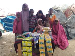 Jamilah* and her children in front of her shop