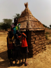 Theresa Abuk Dut outside of a new latrine