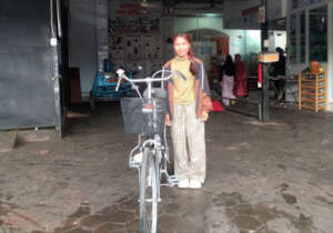 "Sokha" with her bicycle at her home