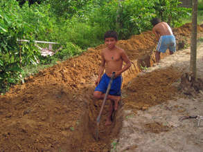 A youth builds his greywater drain.