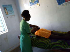 A midwife examining a mother during her 2nd ANC