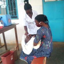 A BENEFICIARY MOTHER IMMUNIZING HER CHILD