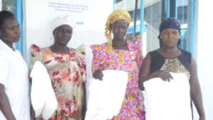 Mothers pose for a photo after receiving nets