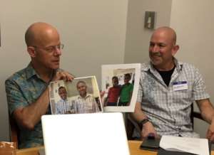 Andy and Andrew with photos of kids they'll host.