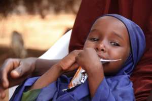 A child eats from a sachet of ready-to-use food