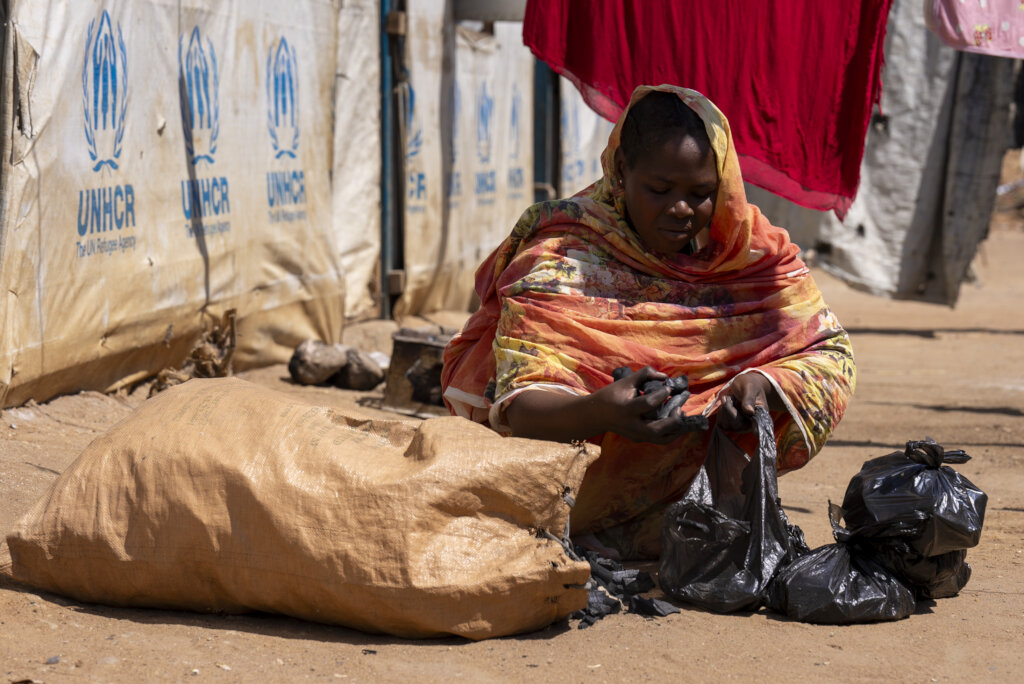 Shaima, a refugee from Sudan selling firewood