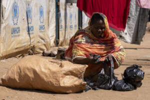 Shaima, a refugee from Sudan selling firewood