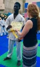 Sonia presenting yellow belt to Issa Ba