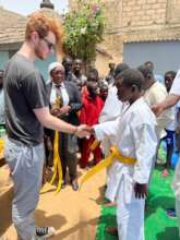 Founder, Robbie Hughes awarding a yellow belt