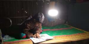 A student reading with the help of solar lamp