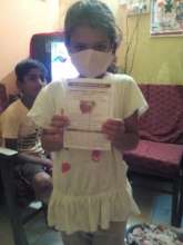 Child receiving a face mask from Desai Foundation.