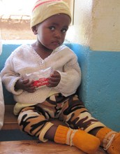 Child holding his Plumpy'nut package