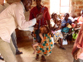 CHW weighing a child during outreach clinic