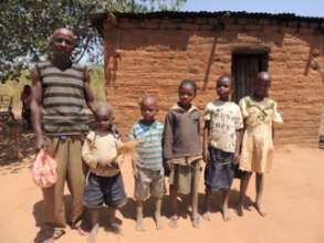 Peter with his children in front of their home