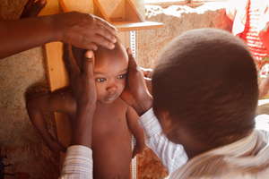 A CHW monitoring a child's growth