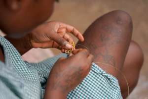 A detainee doing beadwork